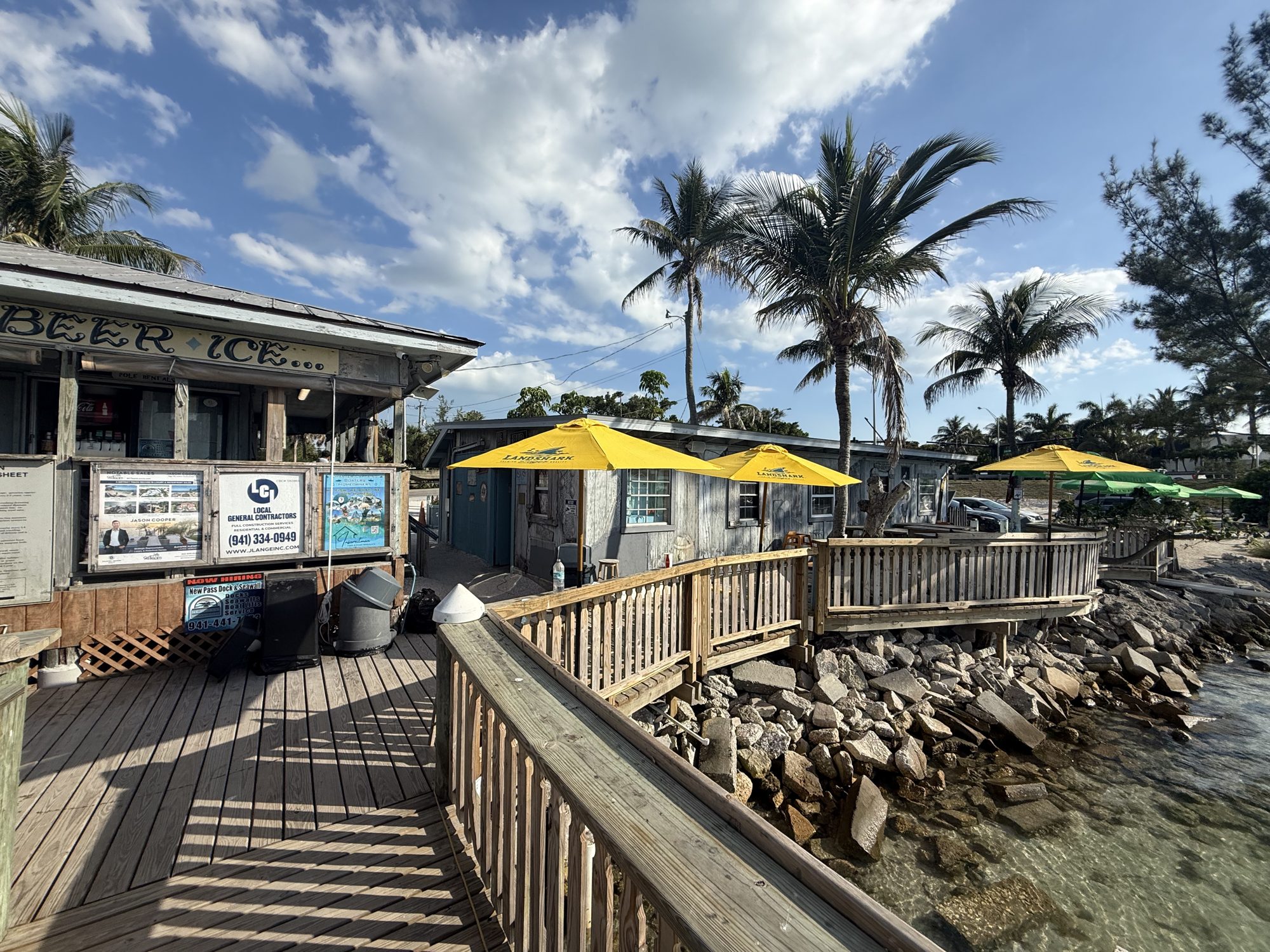 Waterfront dining deck with yellow umbrellas at New Pass Grill