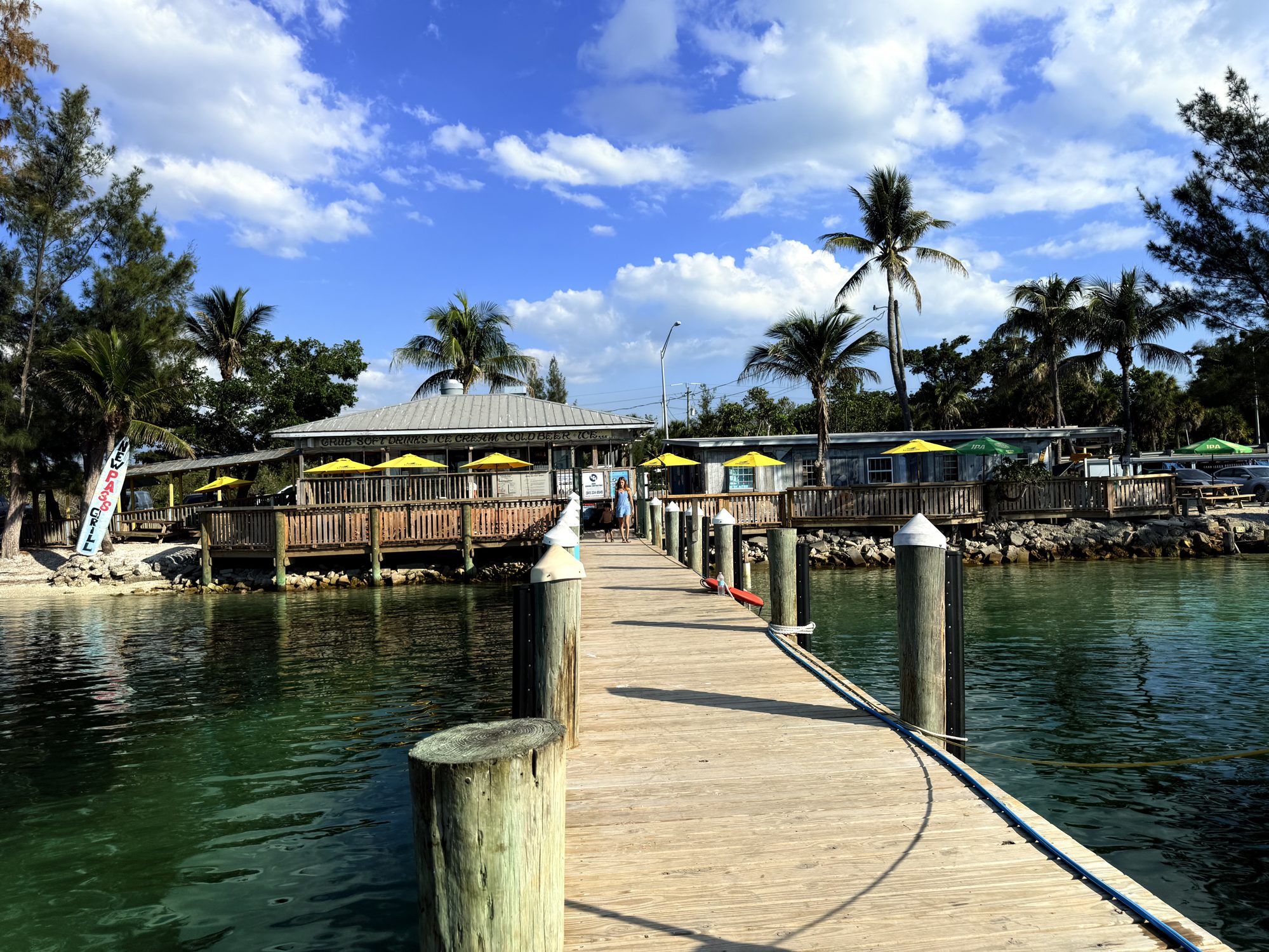 The New Pass Grill dock reaching out over the teal water of New Pass, Sarasota