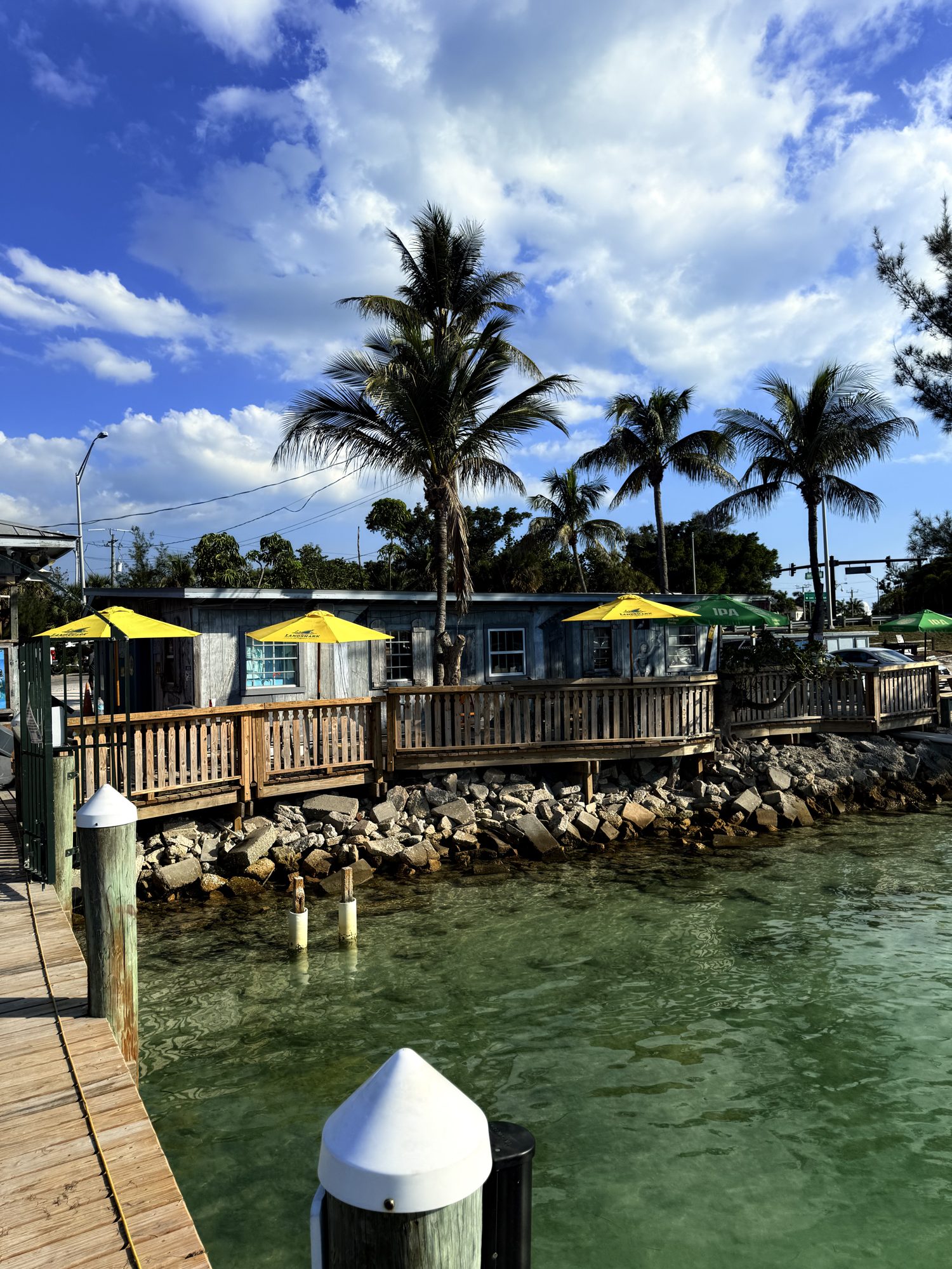 Yellow umbrellas and the dock at New Pass with boats on the water